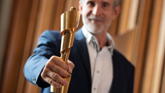 Ulrich Matthes hält den Deutschen Filmpreis in die Kamera © picture alliance/dpa | Christophe Gateau 