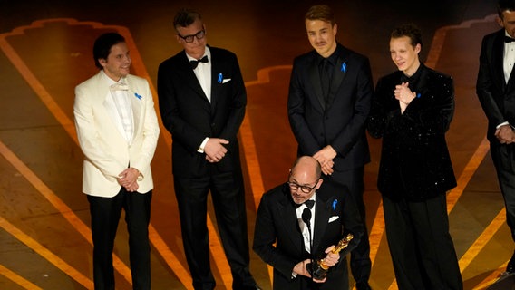 Regisseur Edward Berger mit seinem Filmteam auf der Bühne der Oscar-Gala, dort nimmt er seinen Oscar für den Besten Internationalen Film in Los Angeles entgegen © Chris Pizzello/Invision via AP/dpa +++ dpa-Bildfunk +++ Foto: Chris Pizzello