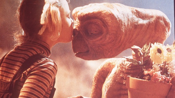 In einer Filmszene aus "E.T. - Der Ausserirdische" von Steven Spielberg küsst Gertie den Außerirdischen E.T. © picture alliance/United Archives 