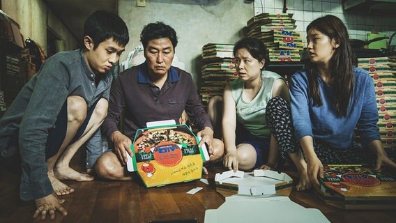 Eine Familie bastelt Pizzapappkartons zusammen - Szene aus "Parasite" von Bong Joon Ho, Gewinner der Goldenen Palme von Cannes 2019 © Koch Films 