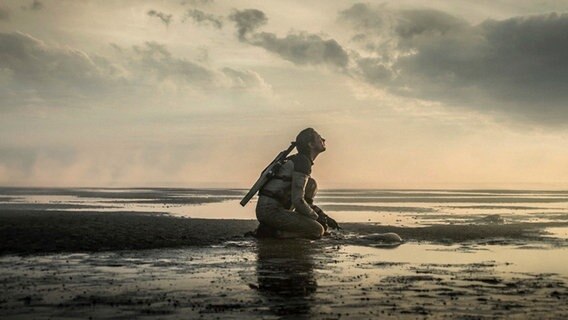 Nora Arnezeder kniet im Watt - Szene aus Tim Fehlbaums deutsch-Schweizer-Berlinale-Film (Reihe Special) "Tides" ©  2021 Constantin Film Verleih GmbH/ Gordon Timpen / BerghausWöbke Filmproduktion GmbH Foto: Gordon Timpen