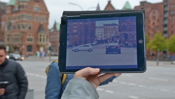 Eine kurze aber heftige Autofahrt führt in "Honig im Kopf" durch die Speicherstadt - hier zu erkennen am Original-Drehort mit einer entsprechenden Szene des Filmes auf einem Tablet © NDR Foto: Patricia Batlle