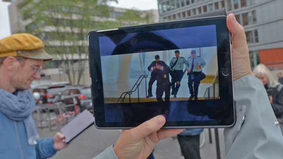 Auf einem Tablet ist eine Szene aus "3 Engel für Charlie" zu erkennen, in der eine Verfolgung auf den Treppen der Elbphilharmonie stattfindet © NDR Foto: Patricia Batlle