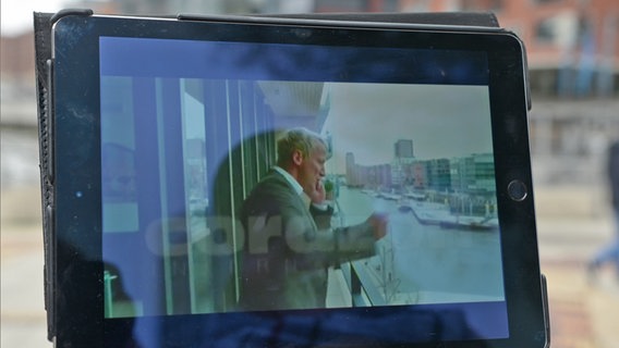 auf einem Tablet ist eine Filmszene mit Wotan Wilke Möhring zu erkennen - Er telefoniert auf einem Balkon in der Hafencity in Fatih Akins Komödie "Soul Kitchen" © NDR Foto: Patricia Batlle