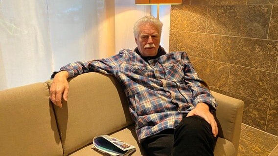 Ein älterer Mann sitzt entspannt auf einem beigen Sofa. © Linda Ebener / NDR Foto: Linda Ebener