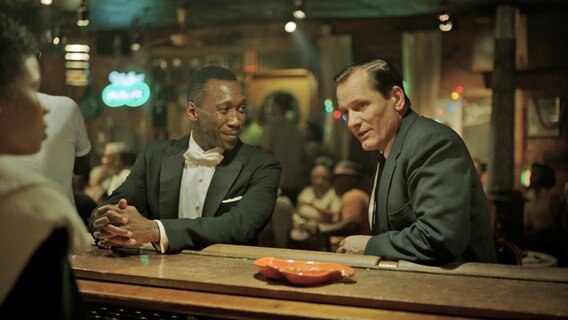 Don Shirley (Mahershala Ali) und Tony Lip (Viggo Mortensen) sitzen in einer Bar - Szene aus dem Film "Green Book" Don Shirley (Mahershala Ali) und Tony Lip (Viggo Mortensen) sitzen in einer Bar - Szene aus dem Film "Green Book" © Entertainment One