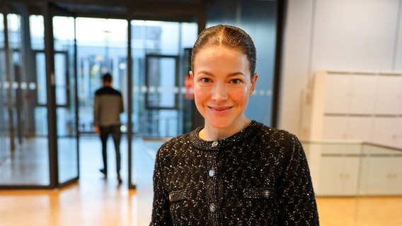 Eine Frau im dunklen Oberteil mit streng zurückgekämmten Haaren lächelt im Gebäude von NDR Kultur - Hannah Herzsprung zu Besuch bei NDR Kultur © NDR / Patricia Batlle Foto: Patricia Batlle