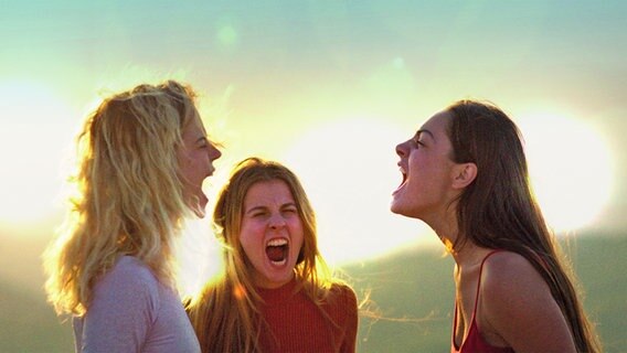 Drei junge Frauen brüllen im Sonnenuntergang - Szene aus "Der Hügel der brüllenden Löwinnen" von Juana Bajrami © Hugo Paturel 