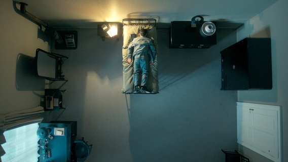 Ein Mann liegt auf dem Bauch im Bett - gefilmt von oben - in der ARD-Serie "Kafka". © NDR/Superfilm 