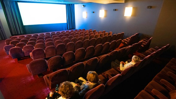 Drei Personen warten auf den Start eines Filmes in einem fast leeren Kinosaal des Kinos am Raschplatz in Hannover © Julian Stratenschulte/dpa +++ dpa-Bildfunk Foto: Julian Stratenschulte