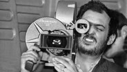 Ein bärtiger Mann hält eine Panavision-Kamera und schaut durch den Sucher - Schwarz-Weiß-Bild von Regisseur Stanley Kubrick 1968 am Set von "Odyssee im Weltraum" © picture alliance / Mary Evans/AF Archive | AF Archive Mary / Evans Picture Library 2020. 