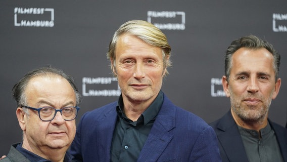Drei Männer auf dem roten Teppich vom Filmfest Hamburg: Leiter Albert Wiederspiel (von links), Schauspieler Mads Mikkelsen und der dänische Regisseur Nikolaij Arcel Drei Männer auf dem roten Teppich vom Filmfest Hamburg: Leiter Albert Wiederspiel (von links), Schauspieler Mads Mikkelsen und der dänische Regisseur Nikolaij Arcel © Marcus Brandt/dpa +++ dpa-Bildfunk +++ Foto: Marcus Brandt