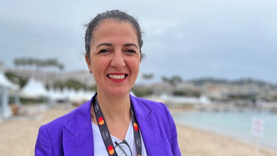 Malika Rabahallah am Strand von Cannes beim Filmfest an der Croisette schaut lächelnd © NDR Foto: Patricia Batlle