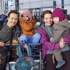 Ein Mann und eine Frau mit zwei Kindern stehen mit Gepäck an einem Bahnhof - Szene aus "Eine Million Minuten" © Warner Bros. Germany 