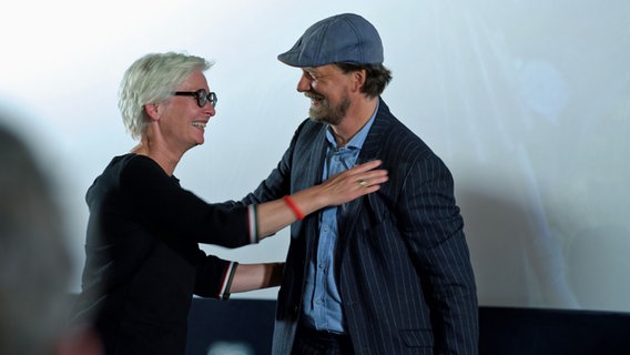 Dörte Hansen und Lars Jessen umarmen sich bei der Premiere des Films "Mittagsstunde". Dörte Hansen und Lars Jessen umarmen sich bei der Premiere des Films "Mittagsstunde". © NDR Foto: Lornz Lorenzen