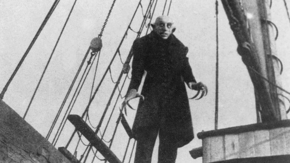 A shivering man with long nails and a grim look stands on the deck of a ship (scene from "Nosferatu - a symphony of horror" by FW Murnau, Germany 1922) Photo: akg-images