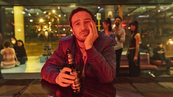 Ein Mann sitzt mit einer Bierflasche in der Hand an einem Kneipentresen. © Sony Pictures Entertainment Deutschland GmbH 