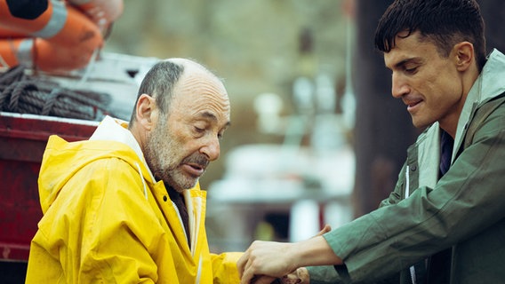 Nando (r.) hilft seinem Großvater beim Entladen der Fracht vom Fischerboot. © ZDF / Ficción Producciones 