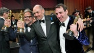 Christian M. Goldbeck, Edward Berger und James Friend vom Film-Team von "Im Westen nichts Neues" bei der Oscar-Preisverlehung in Hollywood. © dpa bildfunk/Invision/AP Foto: John Locher