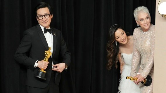Die Schauspieler Ke Huy Quan (von links), Michelle Yeoh und Jamie Lee Curtis  bei der Oscar-Preisverlehung 2023 in Hollywood. © dpa bildfunk/Invision/AP Foto: Jordan Strauss