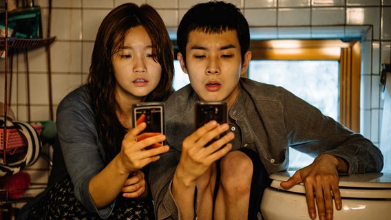 Park So-Dam und Woo-sik Choi mit ihren Handys - Szene aus dem Film "Parasite" von Bong Joon Ho © Koch Films 