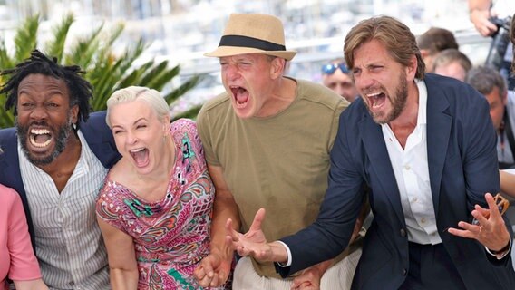 Der schwedische Regisseur Ruben Östlund mit seinen Schauspielern Jean-Christophe Folly (l-r), Vicki Berlin und Woody Harrelson beim Photo-Call zu "Triangle of Sadness" in Cannes, wo der Film im Wettbewerb läuft © IMAGO / TT 