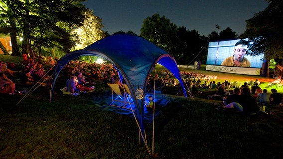 Hunderte Zuschauer sitzen beim Open-Air-Kino im Hamburger Schanzenpark. © Outdoorcine GmbH 