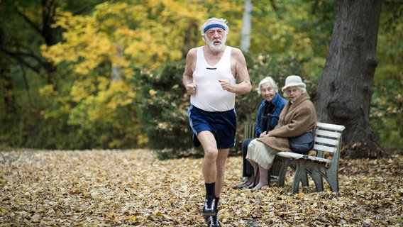 Filmszene aus "Sein letztes Rennen": Dieter Hallervorden joggt durch den Park. Zwei ältere Damen schauen ihm hinterher. © ARD Degeto/BR/Neue Schönhauser Filmproduktion 