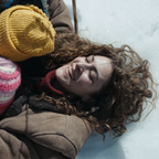 Szene aus dem Film "Sieben Tage": Eine Frau liegt mit zwei Kindern in ihren Armen im Schnee und lacht. © bravenewwork 