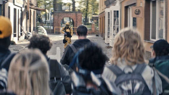 Sløborn - Alles anders": Devid (Aaron Hilmer) und die Gruppe trifft auf den mysteriösen gelben Mann. Dieser ist bewaffnet und trägt einen gelben Schutzanzug. ©  ZDF und Syrreal Entertainment Foto: Christian Alvart