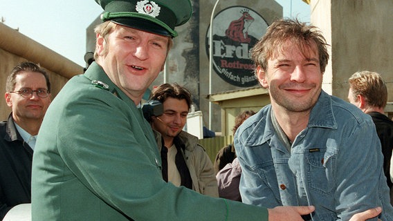 Detlev Buck im Kostüm eines DDR-Volkspolizisten und Regisseur Leander Haußmann während der Dreharbeiten zum Film "Sonnenallee" Detlev Buck im Kostüm eines DDR-Volkspolizisten und Regisseur Leander Haußmann während der Dreharbeiten zum Film "Sonnenallee" © dpa - Fotoreport Foto: Nestor Bachmann