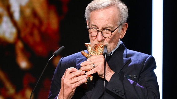 US-Regisseur, Produzent und Drehbuchautor Steven Spielberg hält seinen Goldenen Ehren-Bären fürs Lebenswerk in den Händen und küsst ihn © Jens Kalaene/dpa +++ dpa-Bildfunk ++ Foto: Jens Kalaene
