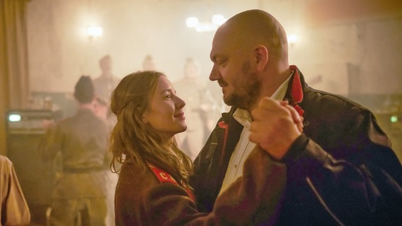 Szene mit zwei tanzenden Menschen (r. Charly Hübner) aus "Die Stillen Trabanten" Szene mit zwei tanzenden Menschen (r. Charly Hübner) aus "Die Stillen Trabanten" © 2022 Sommerhaus Filmproduktion / Warner Bros. Entertainment GmbH