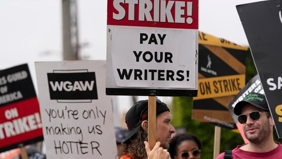 Demonstranten halten Plakate während einer Kundgebung vor dem Paramount Pictures Studio. © Jae C. Hong/AP 