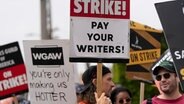 Demonstranten halten Plakate während einer Kundgebung vor dem Paramount Pictures Studio. © Jae C. Hong/AP 