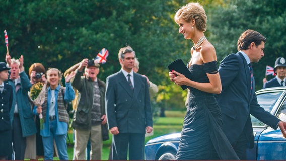 Elizabeth Debicki als Lady Diana in einer Szene, in der sie im Abendkleid aus dem Auto steigt und Menschen grüßt - Aus Staffeln 5 von "The Crown" © Keith Bernstein 