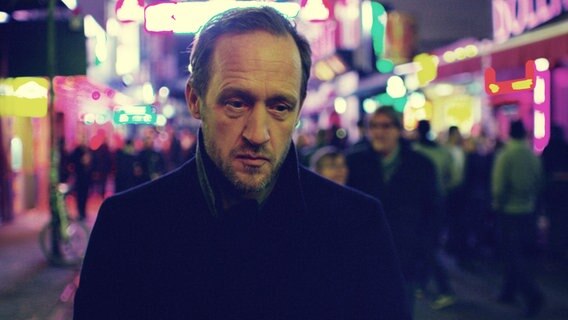 Stephan Kampwirth blickt nachdenklich zu Boden - in einer Filmszene aus "Tian - Das Geheimnis der Schmuckstraße"  "Nordlichter"-Mysteryfilms von Damian Schipporeit © Fiction 2.0 für NDR 