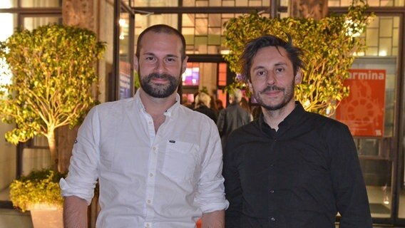 Regisseur Damian Schipporeit (rechts) und Autor und Produzent Stefan Gieren "Tian - Das Geheimnis der Schmuckstraße" vor dem Theater Lübeck © NDR Foto: Patricia Batlle