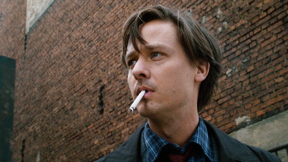 Fabian (Tom Schilling) fume devant une usine.  © Lupa Film / Hanno Lentz / DCM 