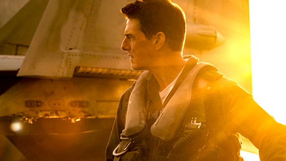 Schauspieler Tom Cruise schaut über Kopf aus seinem Flugzeug auf Berge - Szene aus "Top Gun Maverick" © Paramount Pictures France 