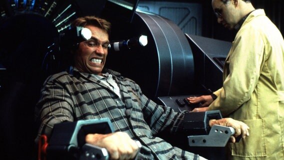 Filmstill aus "Total Recall - Totale Erinnerung" mit Arnold Schwarzenegger als Douglais Quaid, der sich fremde Erinnerungen implantieren lässt © picture alliance / United Archives 