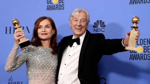 Der niederländische Regisseur Paul Verhoeven hält seinen Schauspielerin Isabelle Huppert in Beverly Hills im Arm. Beide halten jeweils ihren Golden Globe für den besten fremdsprachigen Film für "Elle" und für die "beste Schauspielerin" hoch © Imago/UPI Photo 