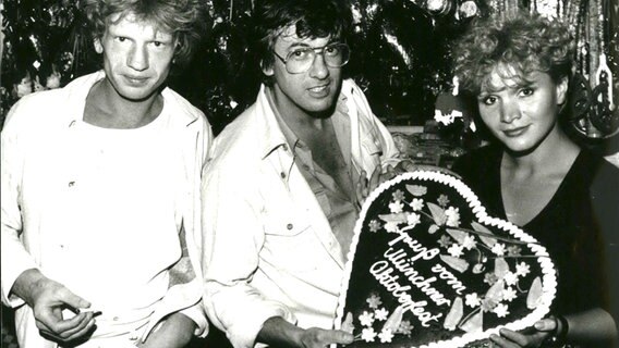 Der niederländische Regisseur Paul Verhoeven (Mitte) mit den Schauspielern Renee Soutendijk (r.) und Hans Van Tongeren seines Filmes "Spetters" auf dem Oktoberfest 1980 in München © imago/ZUMA/Keystone 