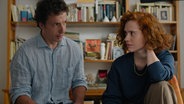 Szene aus dem Film "Volveréis - Ein fast klassischer Liebesfilm": Ein Mann und eine Frau sitzen nebeneinander und schauen sich skeptisch an. © Lisbeth Salas 