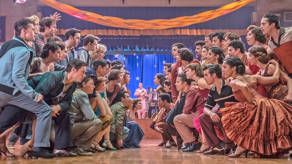 Zwei Gruppen von Tänzerinnen und Tänzern blicken sich herausfordernd an - Szene aus dem Film "West Side Story" von Steven Spielberg © 2020 Twentieth Century Fox Film Corporation. Foto: Niko Tavernise