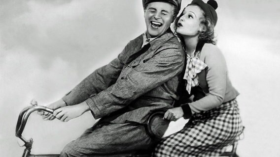 Szene aus dem deutschen Spielfilm: "Ein blonder Traum" (1932) Willy Fritsch und Lilian Harvey als Traumpaar auf dem Tandem.  