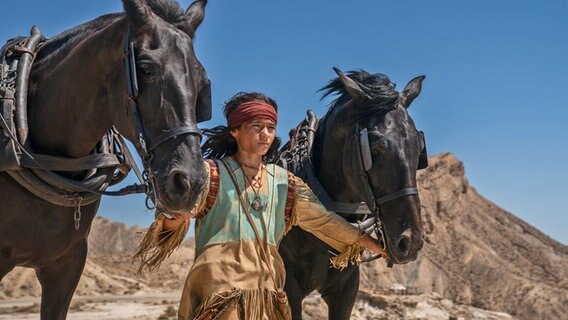 Szene aus "Der junge Häuptling Winnetou" mit Mika Ullritz und zwei Pferden © Warner Media 