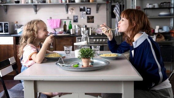 Szene mit Emilia Schüle und einem Mädchen beim Spaghetti-Essen aus der Komödie "Wunderschön" von Karoline Herfurth © Warner Brothers 