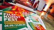 Plakate für das 34. Filmkunstfest Mecklenburg-Vorpommern liegen im Vorraum im Festivalkino «Capitol» © Jens Büttner/dpa +++ dpa-Bildfunk +++ 