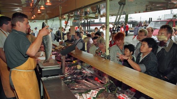 Vor einem Fischstand auf dem Hamburger Fischmarkt stehen viele Kunden. © picture-alliance / dpa | Markus Beck 
